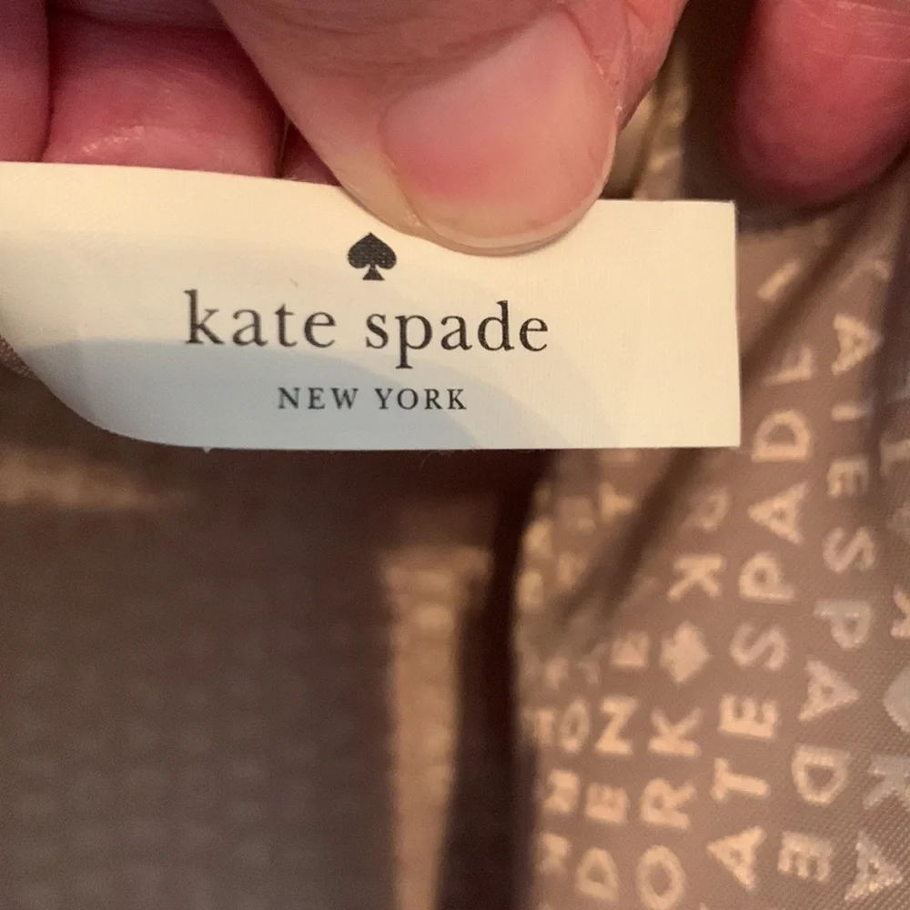 Kate Spade cream colored cloth tote with green leaf pattern.